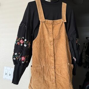 Tan and brown corduroy dungaree dress with floral embroidery on sleeves
